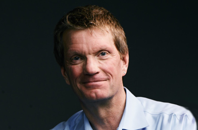 Portrait of Mike Olson against a dark blue background