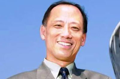 Portrait of Pehong Chen smiling in front of a blue background