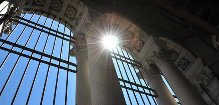 Picture taken in an upward angle of the sun shining into gate of stadium
