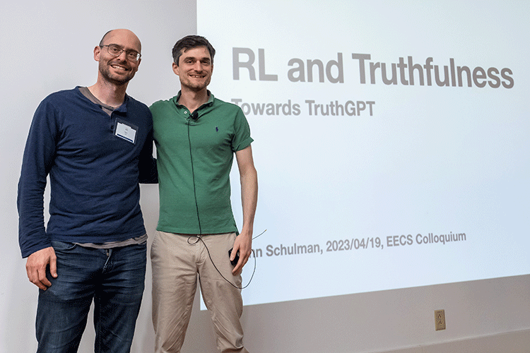 John Schulman and Peter Abbeel pose on a stage in front of a projection that reads "RL and truthfulness"
