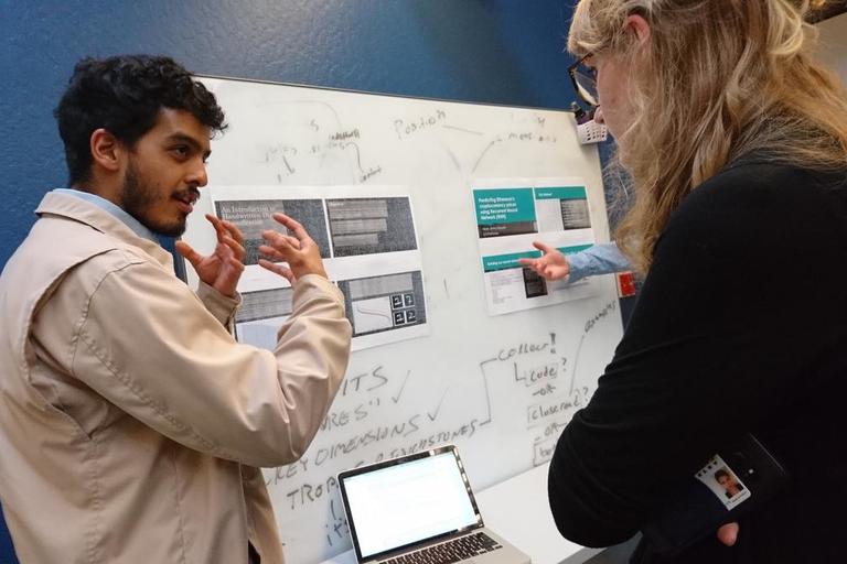 a student presenting their research project to another student at the spring 2018 data scholars project showcase